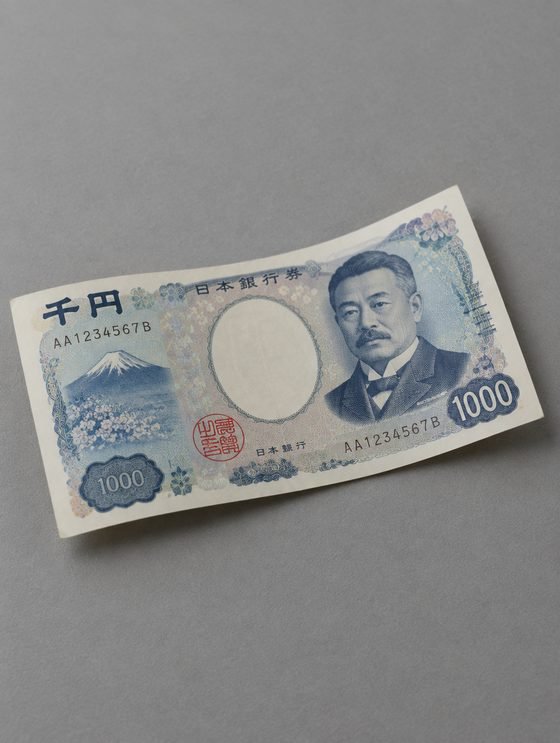 A 1000 yen note on a grey table