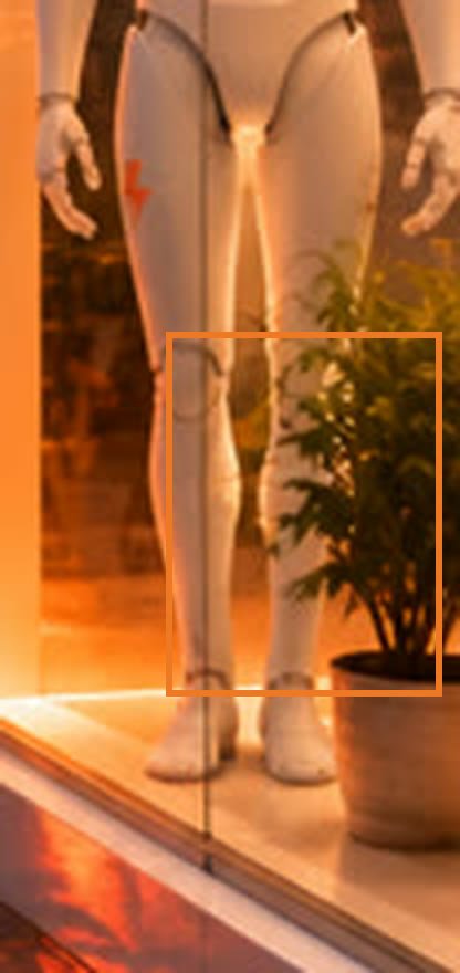 The bottom of a robot shop window: the robot&rsquo;s feet and a green plant in a pot, marked with an orange frame